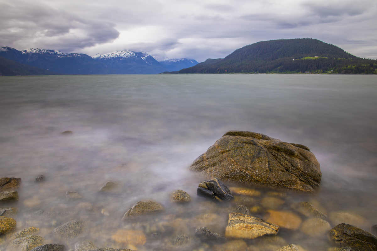 Rock and ocean with mountains in background. Haines Beach