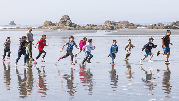 Northwestern Portland Area Tribal Youth Running on Coastline Youth Running on beach coast.