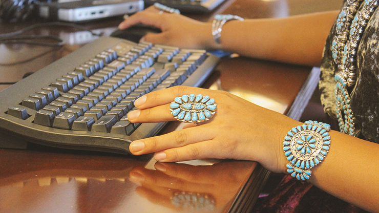 Young AI/AN Woman uses computer to access internet. Young AI/AN Woman uses computer to access internet.