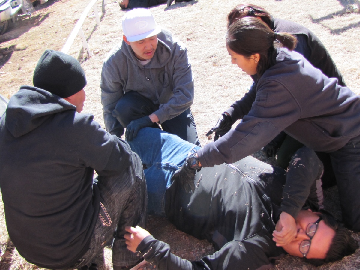 Wilderness First Responder students from Navajo Nation practice assessing a patient during a field exercise.