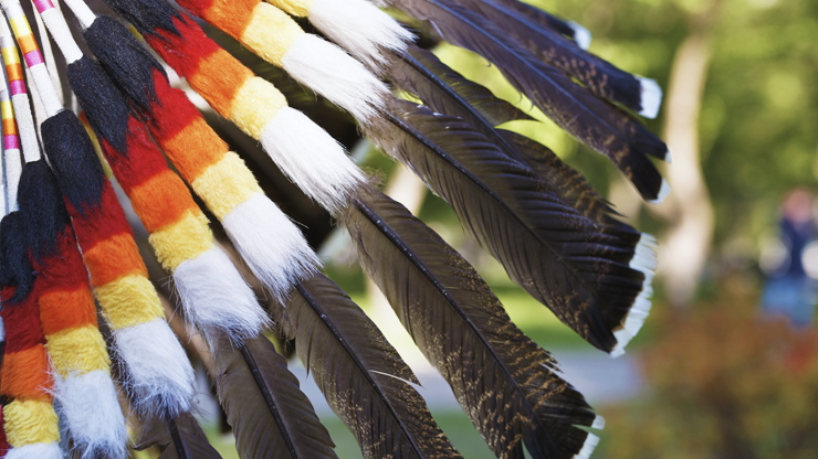 Colorful Headress. Feathers with decorative thread wrapping the ends. Colors are black, red, orange, yellow and white. Feathers are brown with black and white tips.