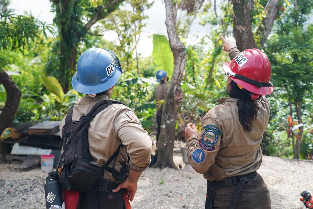 Two Americorps National Civilian Conservation Corps members in the forest.