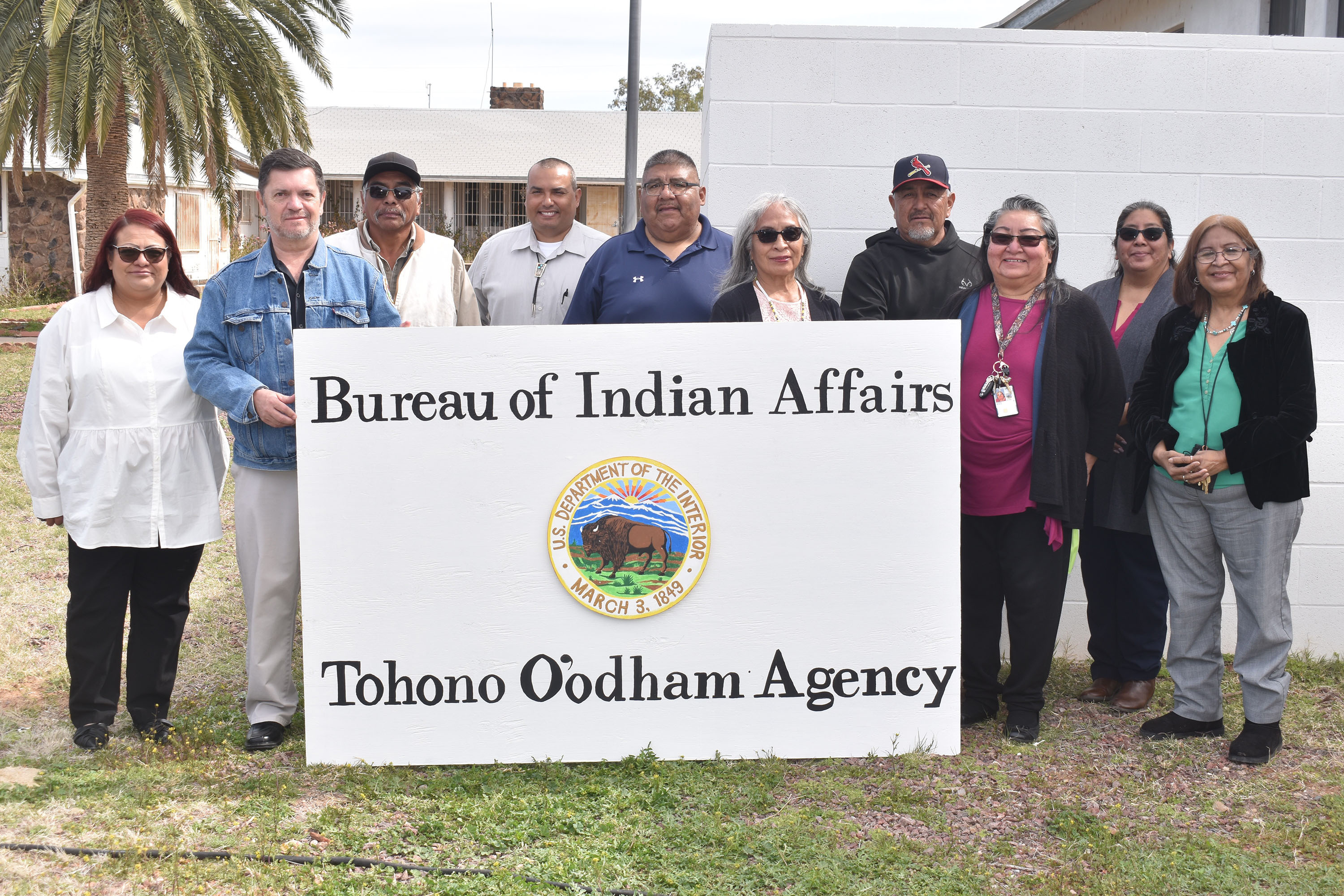 BIA and BTFA staff holding the new sign reading "Bureau of Indian Affairs Tohono O'odham Agency." 