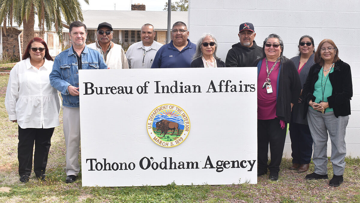 BIA and BTFA staff holding the new sign reading "Bureau of Indian Affairs Tohono O'odham Agency."