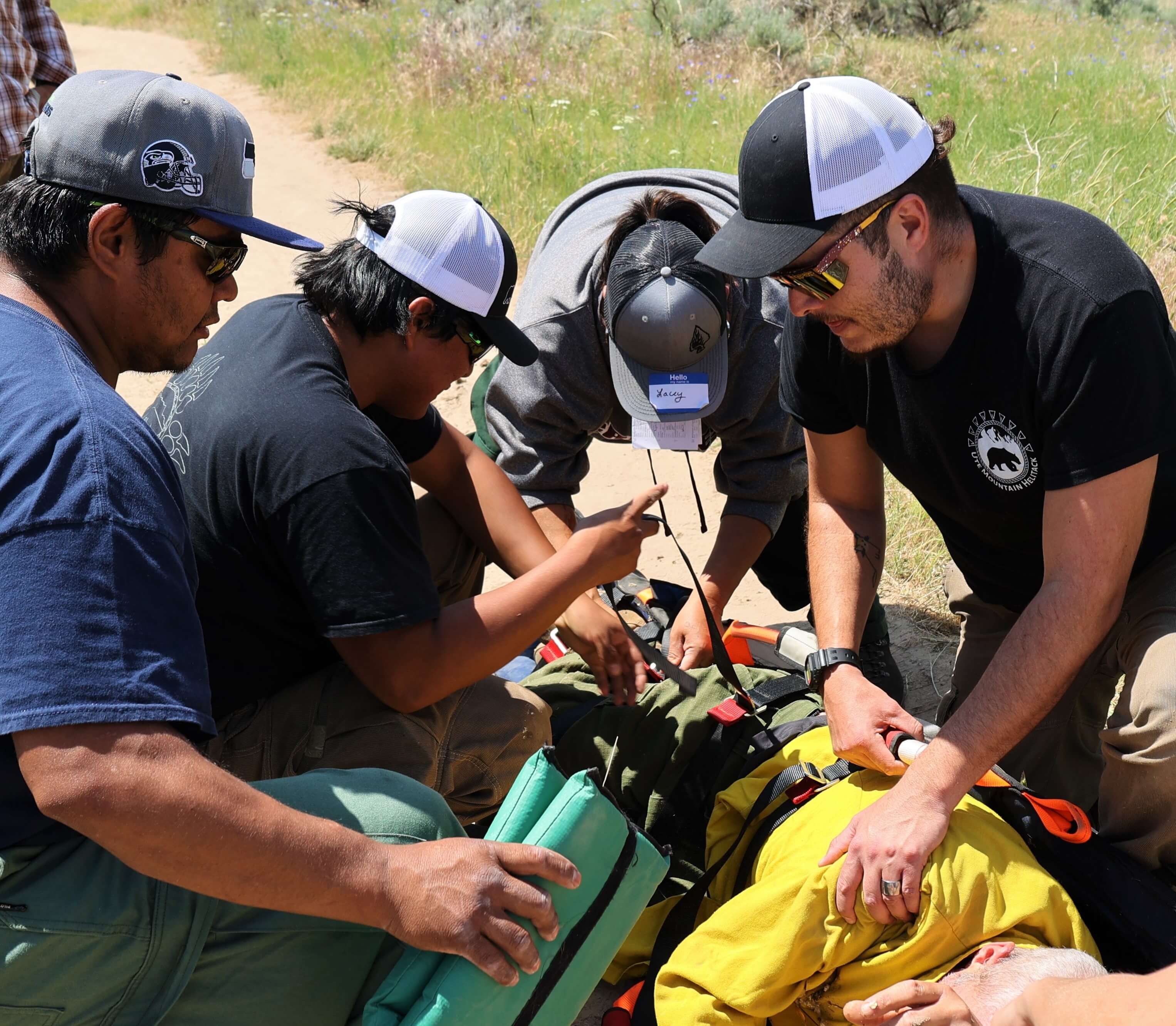 Medical Incident Technician training participants take part in a practice medical scenario outdoors. Medical Incident Technician training participants take part in a practice medical scenario outdoors.