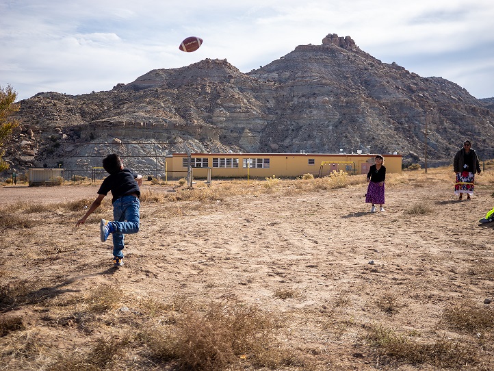 Students throwing a football outside at T'iis Nazbas Community School in Arizona. 