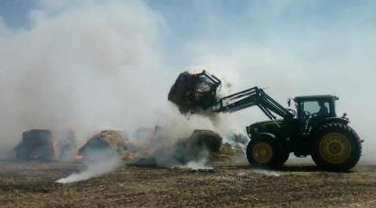 Dozer moves burning hay bails during the Torkse Fire, August 2012
