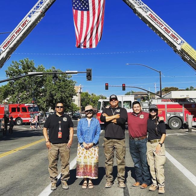 BIA fire leadership stand together in front of fire trucks following the afternoon memorial service.