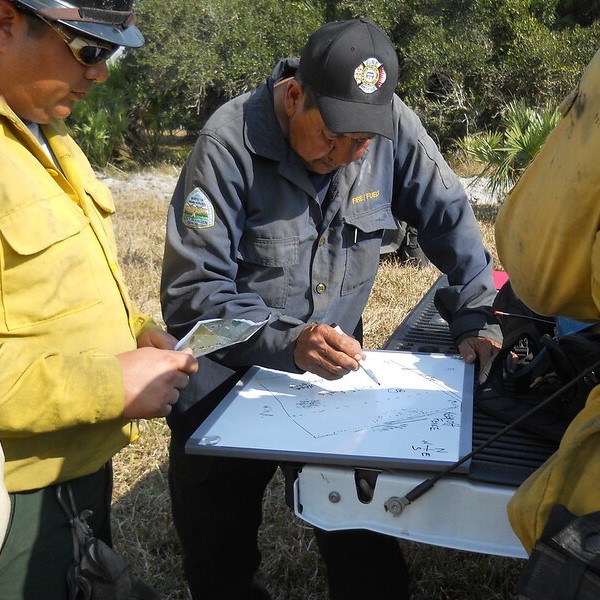 A firefighter reviews a plan written on a whiteboard.