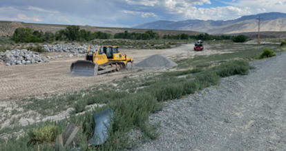 Staged rip rap and equipment near service spillway