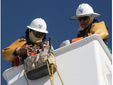 Two utility workers with hard hats working