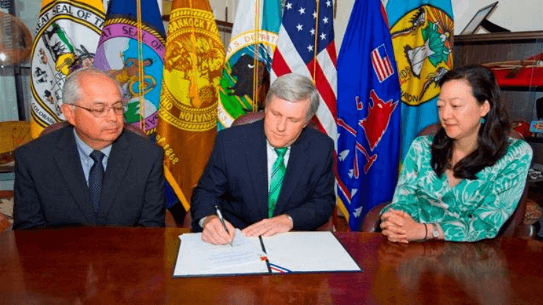 Deputy Interior Secretary David Hayes signs the contract for services with the Bronner Group, a woman-owned small business as Interior's Assistant Secretary Larry Echo Hawk (L) and Assistant Secretary Rhea Suh look on.