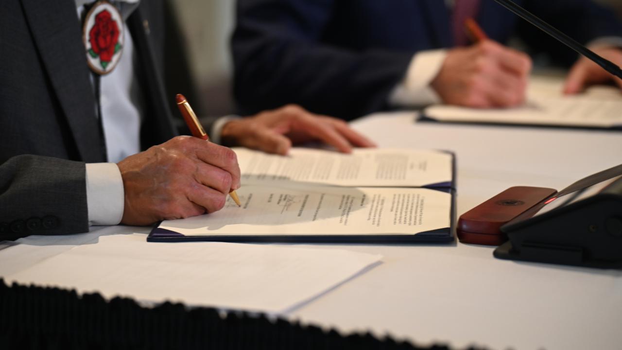 Two people signing documents. 