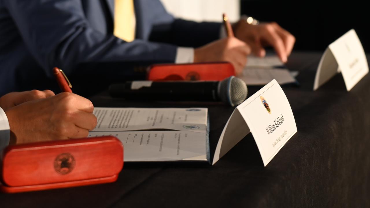 Two people signing a document.