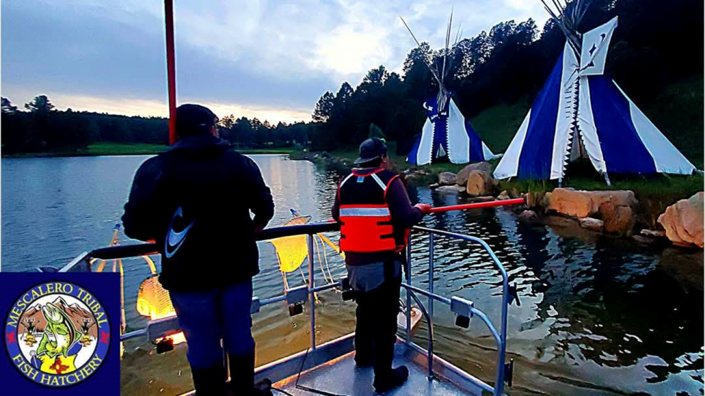 Mescalero Tribal Fish Hatchery Youth Program. Two people stand on a dock looking out at the water.