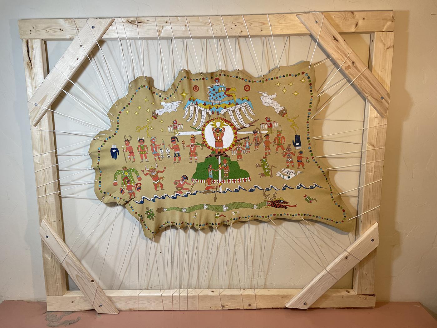 Hide stretched in a frame painted with thunderbird iconography in the upper segment, separating human and animal figures in the middle segment, above a large serpent in the lower segment.